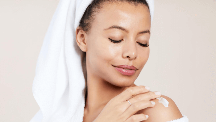 Woman applying moisturizer as part of her bedtime beauty routine